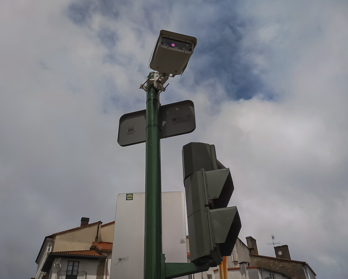 Composición abstracta de elementos del mobiliario urbano de señales, cámara y semáforo.