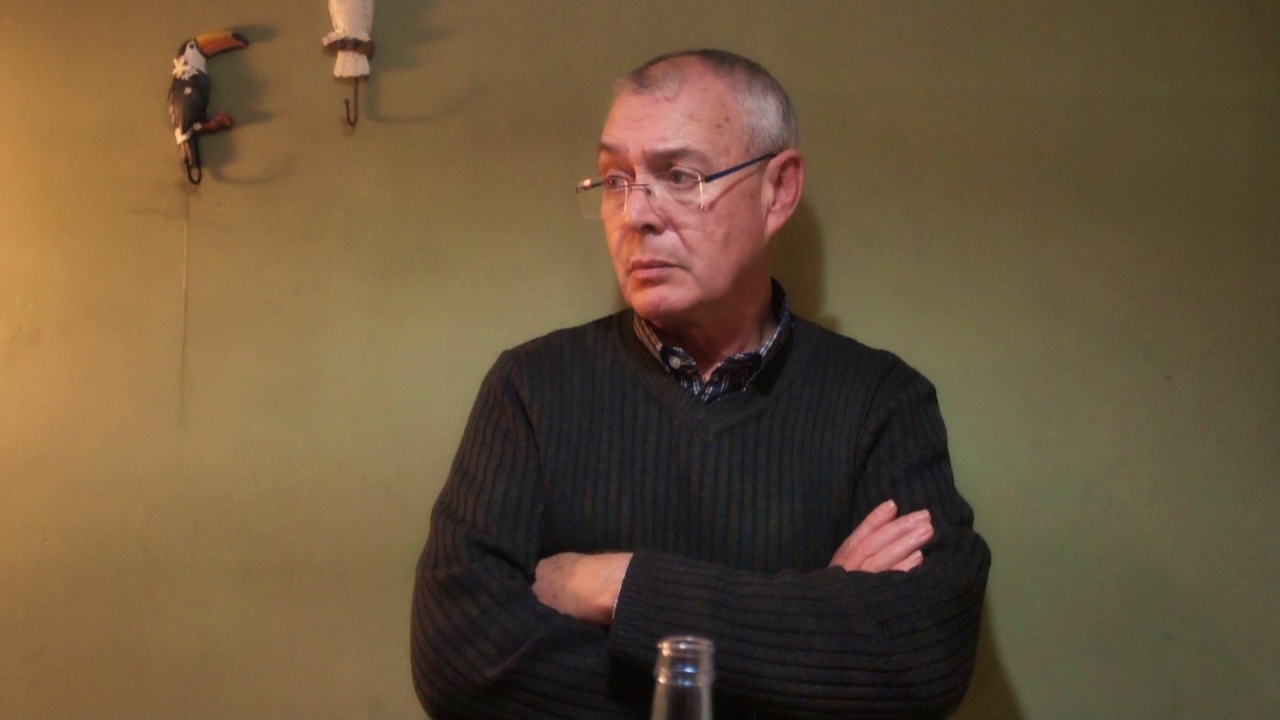 Plano medio de hombre cruzado de brazos, observando. 